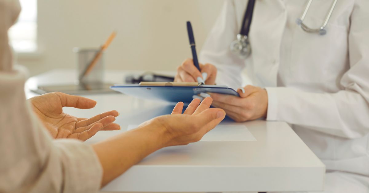 A doctor consulting with a patient in a chiropractic clinic, illustrating how Proactive Marketing helps practices turn inquiries into scheduled appointments