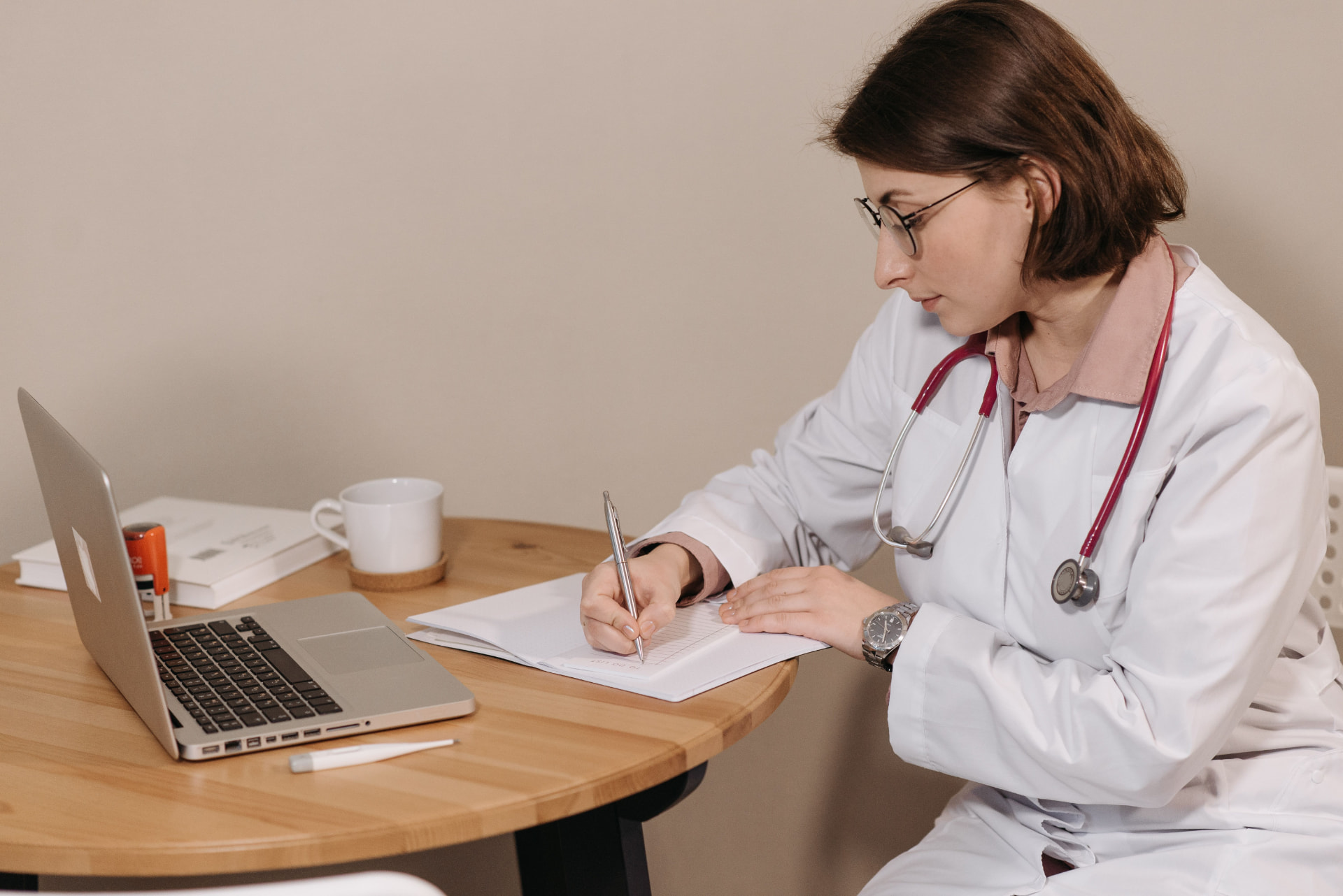 Proactive Marketing healthcare professional reviewing notes and working on a laptop at a desk